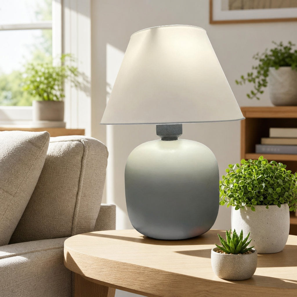 Abajur de Mesa em Cerâmica e Tecido Bivolt sobre mesa lateral em sala iluminada com plantas naturais - Vittara Decor