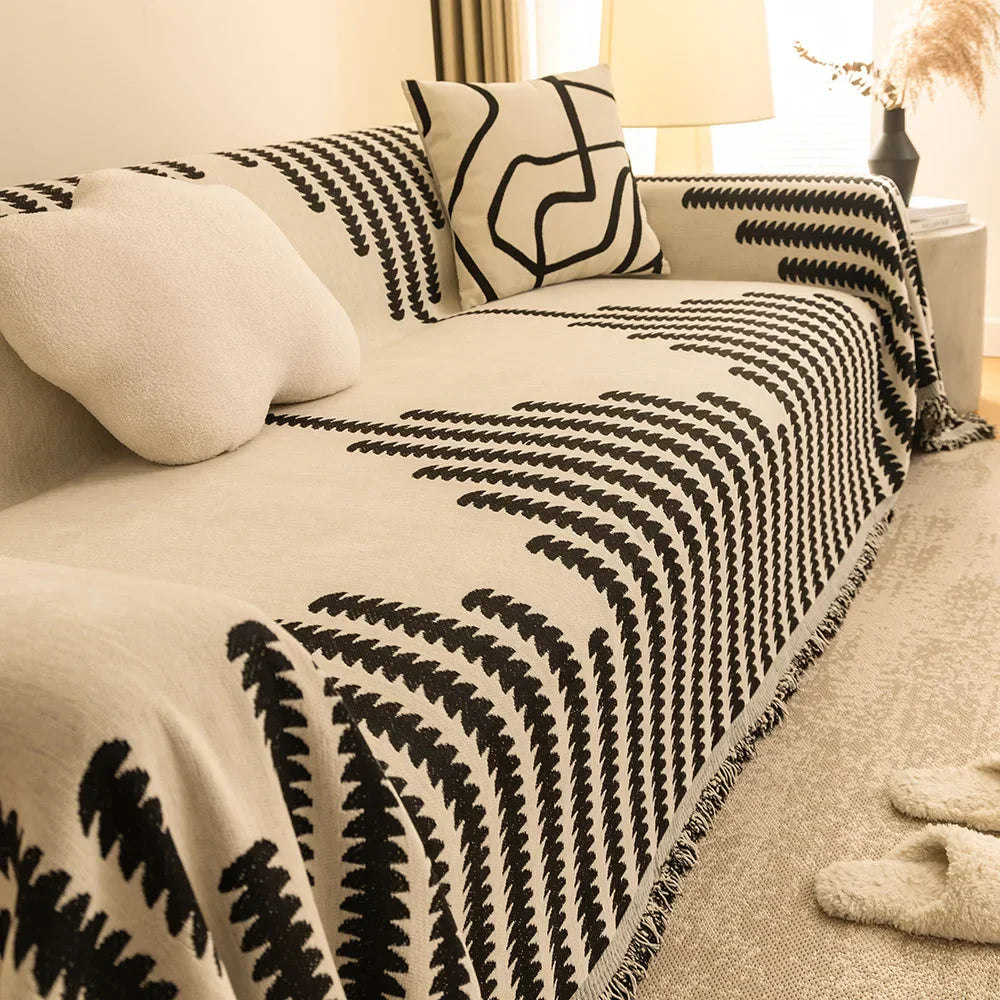 Manta para Sofá Jacquard com franjas cobrindo sofá bege em sala com luz natural - Vittara Decor