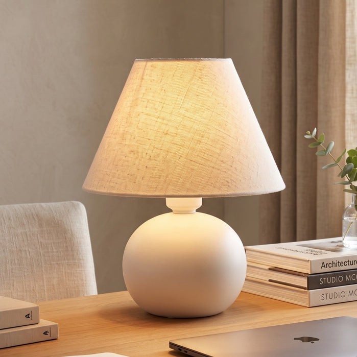 Abajur de cerâmica bolinha off white aceso na escrivaninha - Vittara Decor