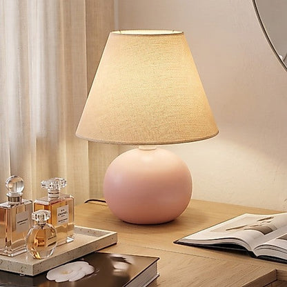 Abajur de cerâmica bolinha rosa queimado ao lado de perfumes - Vittara Decor
