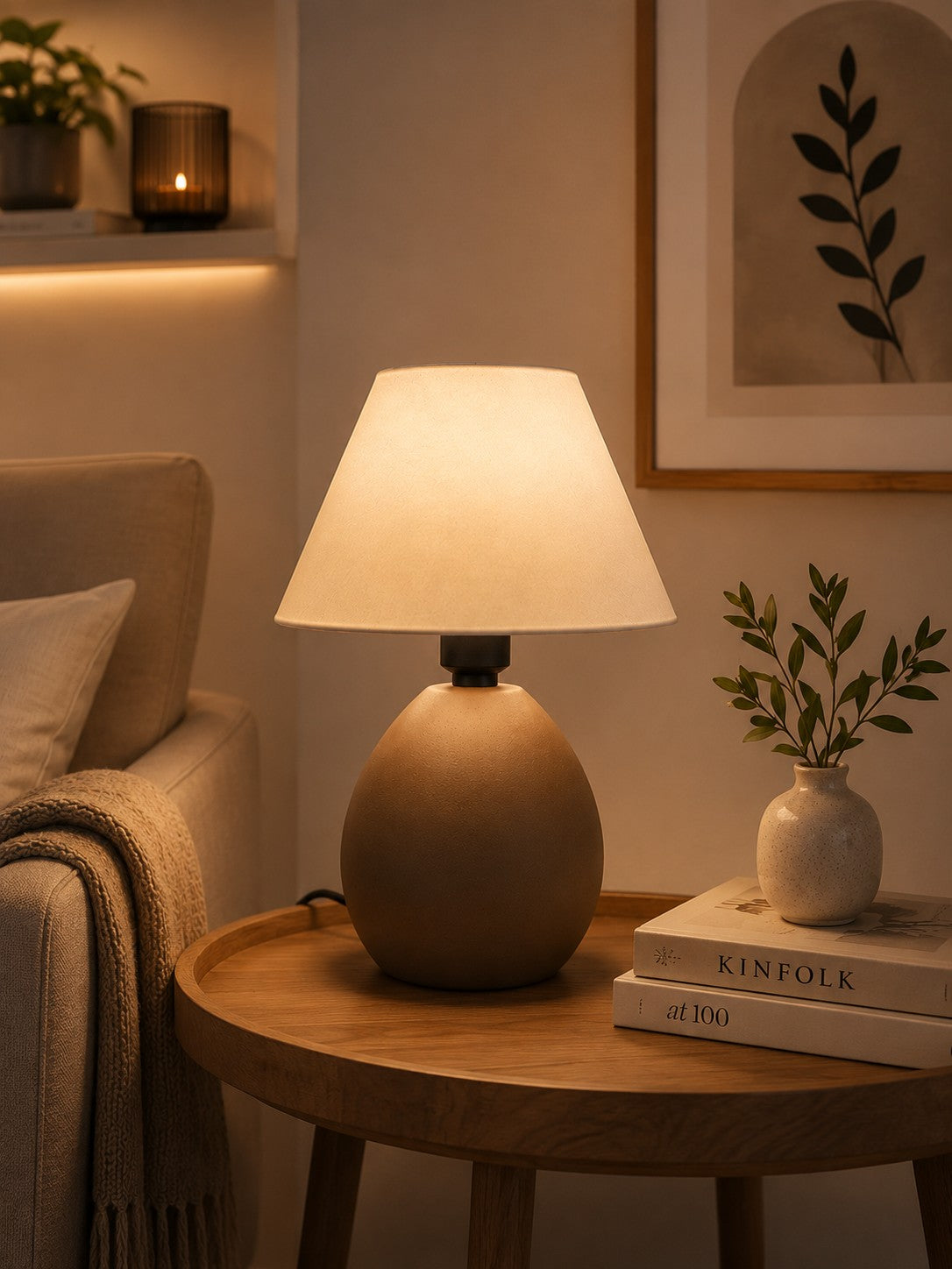 Abajur de cerâmica elipse capuccino no cantinho de leitura ao lado do sofá - Vittara Decor