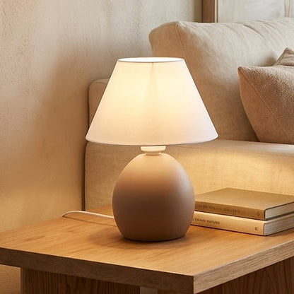 Abajur de cerâmica elipse marrom amêndoa em mesa de madeira na sala - Vittara Decor