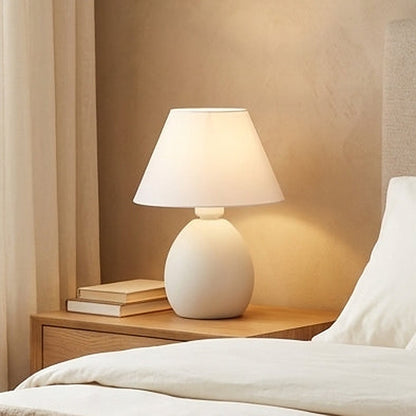 Abajur de cerâmica elipse off white no criado-mudo com livros - Vittara Decor