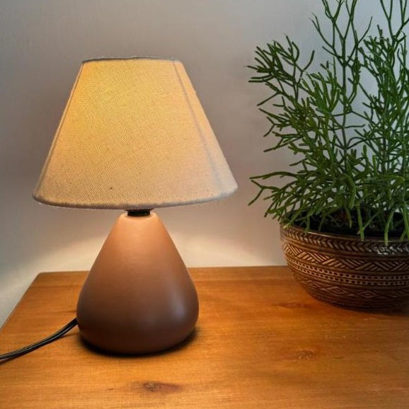 Abajur de cerâmica gota marrom escuro ao lado de vaso de planta - Vittara Decor