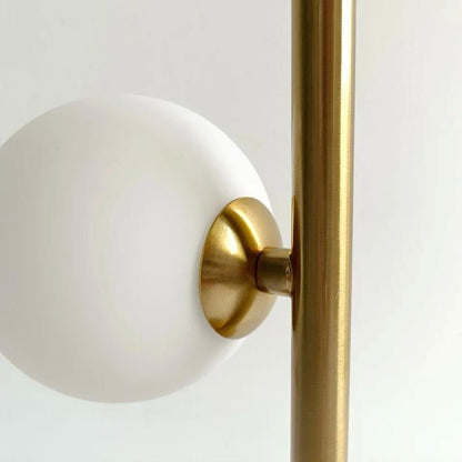Detalhe do globo de vidro branco encaixado na haste dourada do abajur de mesa - Vittara Decor