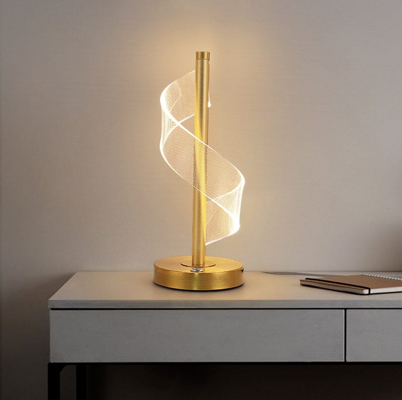 Abajur de mesa touch LED espiral dourado aceso sobre aparador cinza - Vittara Decor