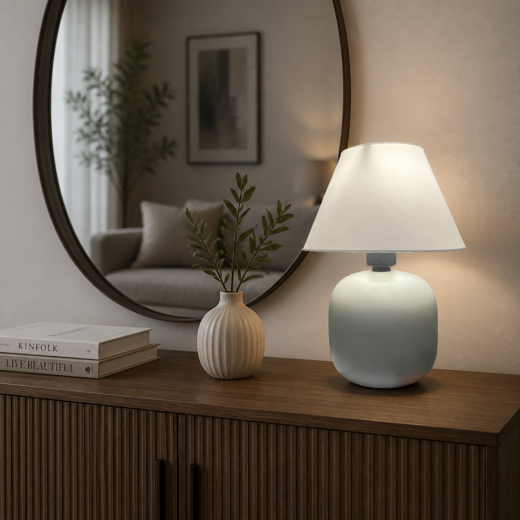 Abajur de Mesa em Cerâmica e Tecido Bivolt sobre aparador de sala com espelho oval ao fundo - Vittara Decor