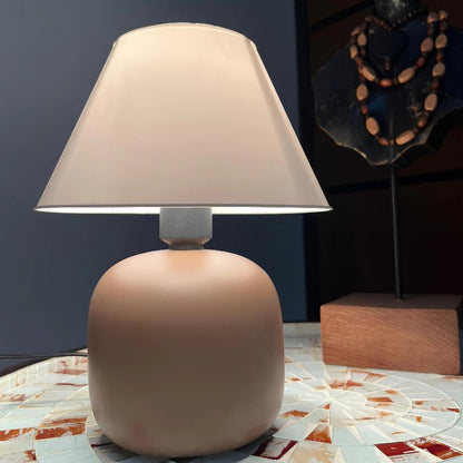 Abajur de Mesa em Cerâmica e Tecido Bivolt na cor Marron Claro com decoração ao fundo - Vittara Decor