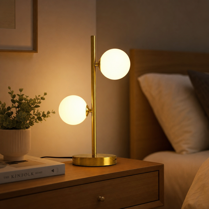 Abajur de mesa dourado com globos de vidro aceso na cabeceira a noite - Vittara Decor