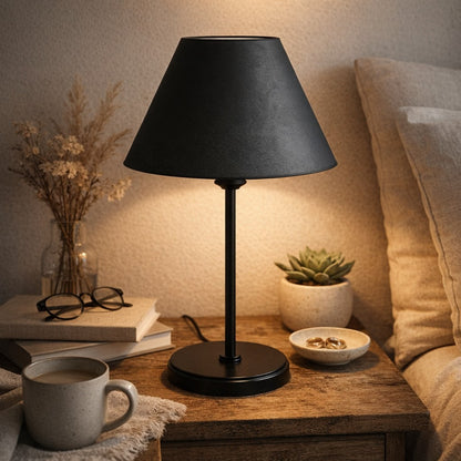 Abajur de mesa de ferro preto aceso na cabeceira com livros - Vittara Decor