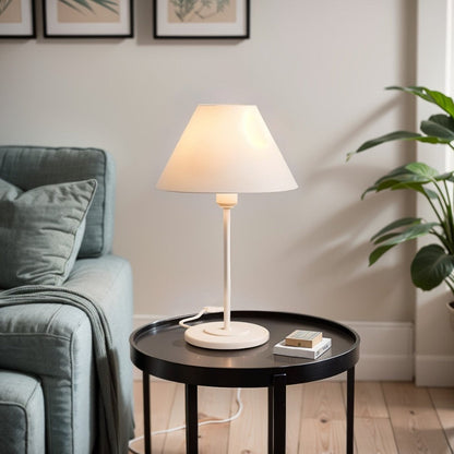 Abajur de mesa de ferro branco aceso em mesa lateral da sala - Vittara Decor
