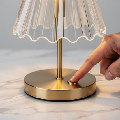Detalhe do sensor touch na base dourada do abajur portátil de cristal — Vittara Decor
