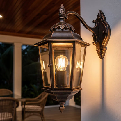 Arandela colonial bronze em varanda coberta com mobiliario de rattan e luz quente — Vittara Decor