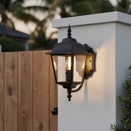 Arandela colonial preta em fachada classica com jardim tropical no entardecer — Vittara Decor