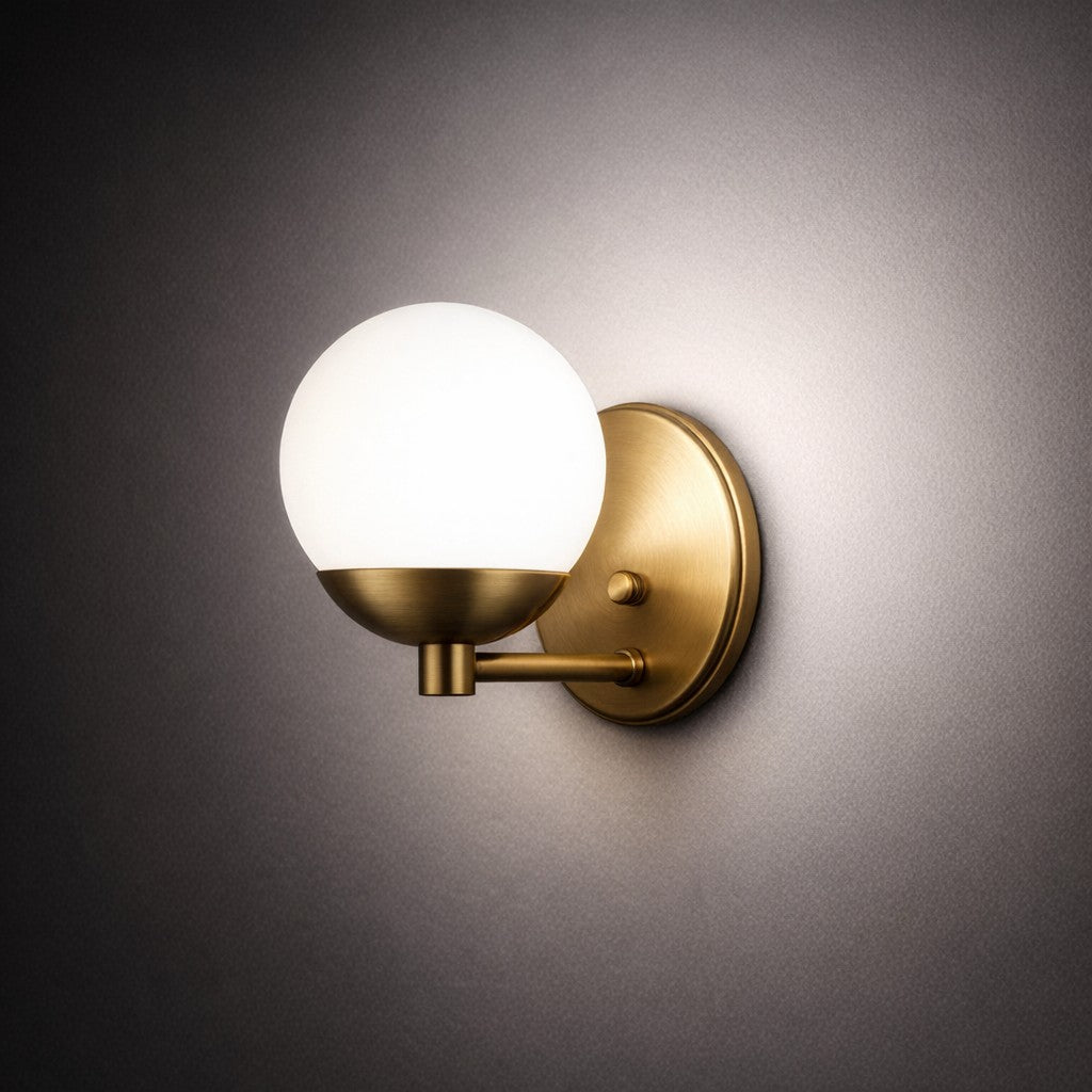 Arandela de parede dourada acesa em ambiente escuro, com luz espalhada pela parede - Vittara Decor