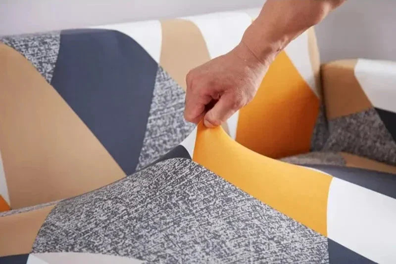 Detalhe da instalação da capa de sofá elástica estampada mostrando ajuste do elástico na base - Vittara Decor
