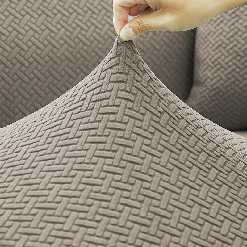 Detalhe da elasticidade do tecido jacquard da Capa de Sofá Elástica sendo puxado - Vittara Decor