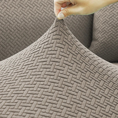 Detalhe da elasticidade do tecido jacquard da Capa de Sofá Elástica sendo puxado - Vittara Decor