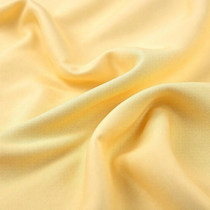 Capa de sofá Jacquard bege amarelado dobrada fundo branco - Vittara Decor