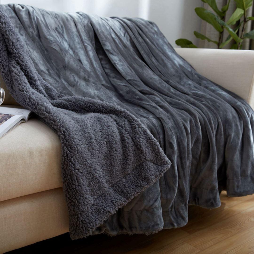 Cobertor sherpa dupla face cinza estendido sobre sofa com lado felpudo a mostra - Vittara Decor
