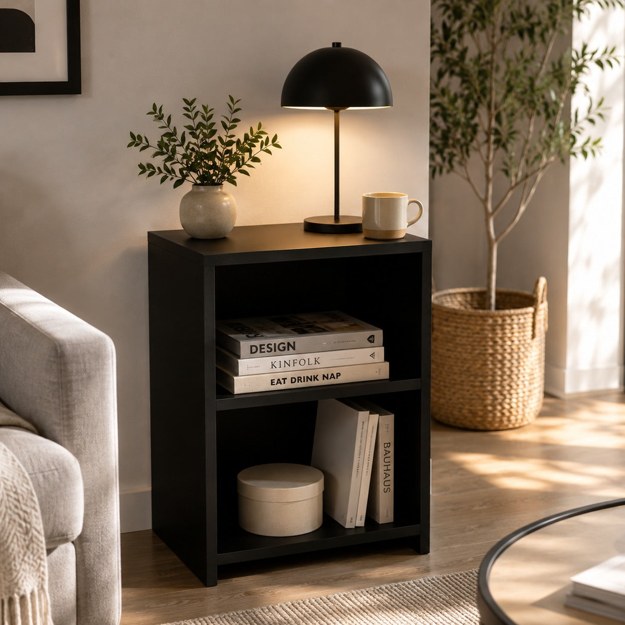 Criado mudo preto usado como mesa de apoio ao lado da poltrona na sala - Vittara Decor