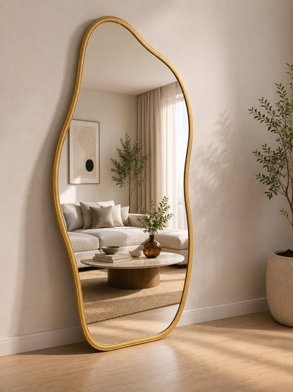 Espelho orgânico de corpo inteiro dourado refletindo o sofá da sala - Vittara Decor