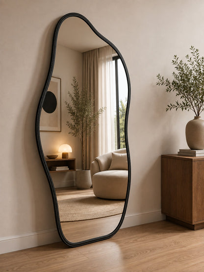 Espelho orgânico de corpo inteiro preto ao lado de poltrona na sala - Vittara Decor