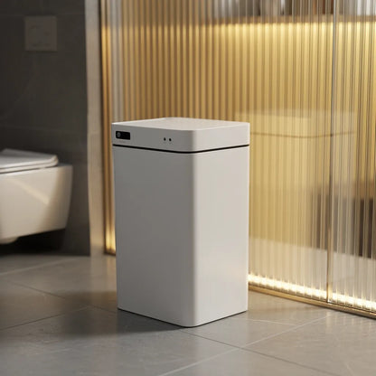 Vista lateral da lixeira automática com sensor em banheiro sofisticado com piso de pedra e painel de vidro - Vittara Decor