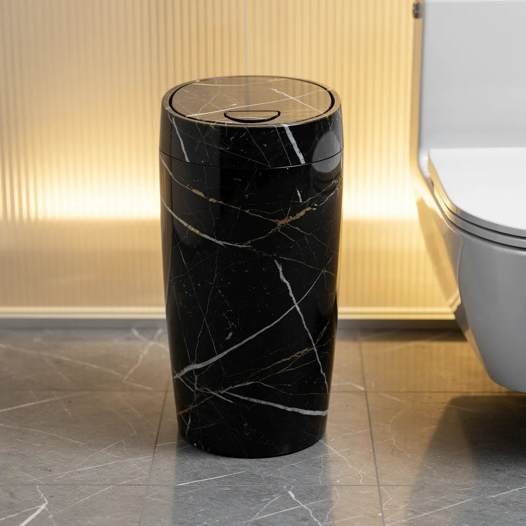 Lixeira multiuso com tampa design moderno mármore preto ao lado do vaso em banheiro com painel dourado - Vittara Decor