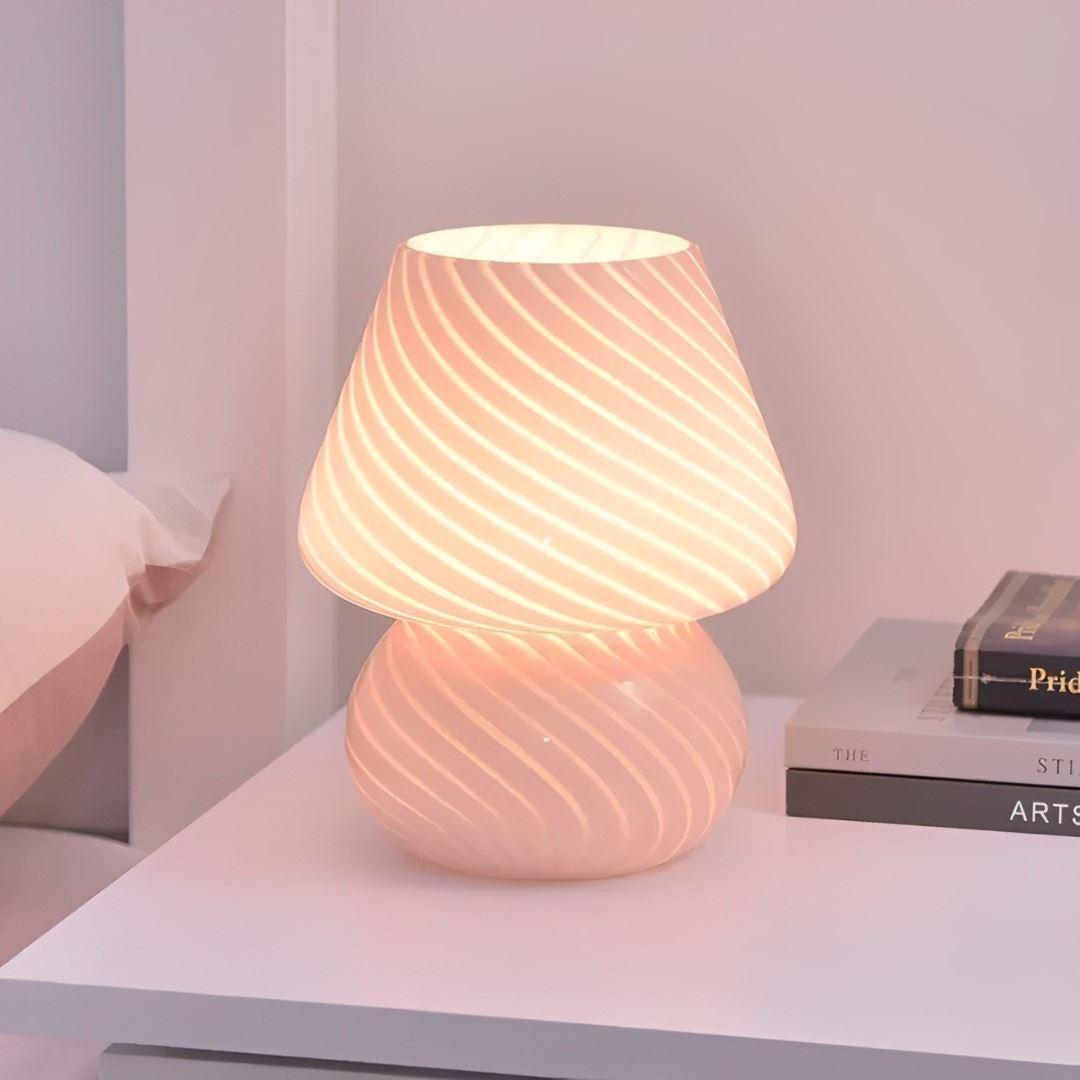 Luminária cogumelo rosa acesa na mesa de cabeceira com livros - Vittara Decor