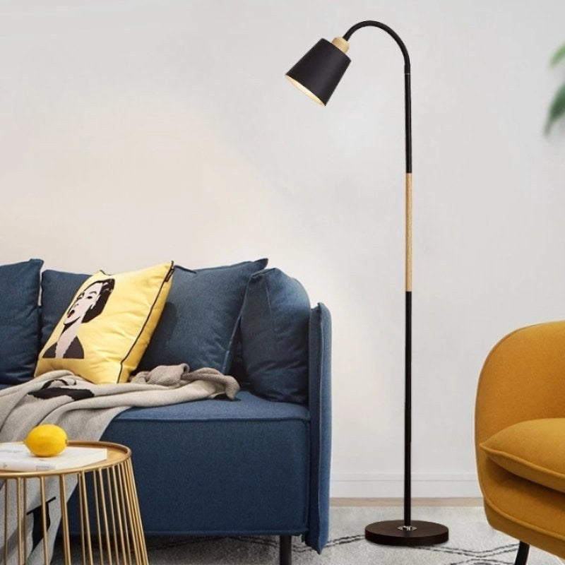 Luminária de chão articulada preta acesa na sala ao lado do sofá - Vittara Decor