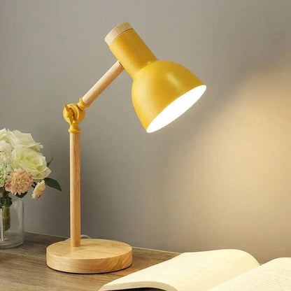 Luminária de mesa articulada amarela acesa na escrivaninha de leitura - Vittara Decor