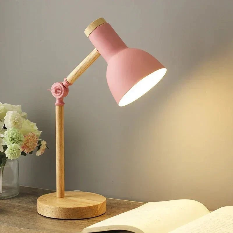 Luminária de mesa articulada rosa acesa na escrivaninha com flores - Vittara Decor