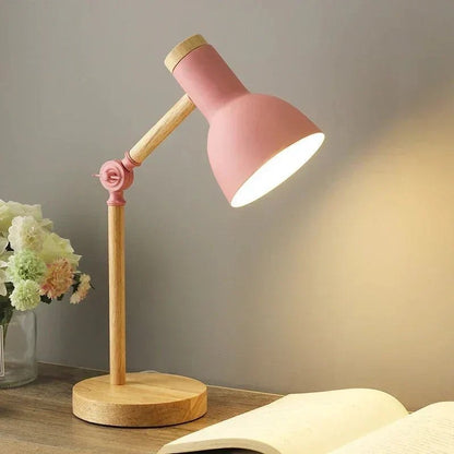 Luminária de mesa articulada rosa acesa na escrivaninha com flores - Vittara Decor