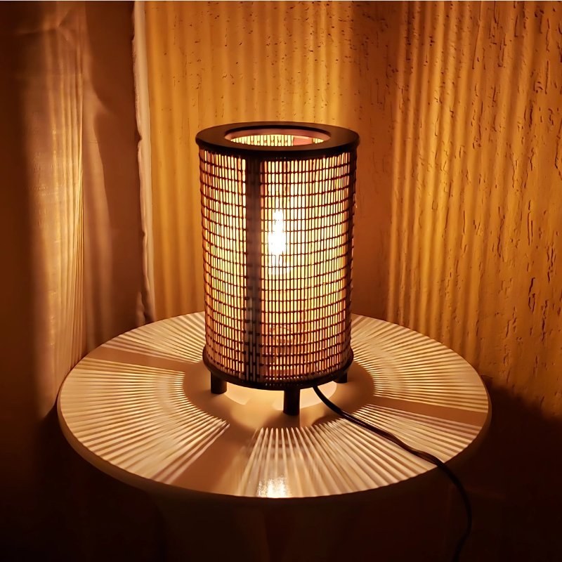 Luminária de mesa de fibra natural acesa sobre mesa de madeira - Vittara Decor
