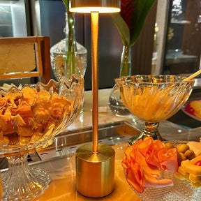 Luminária de mesa sem fio dourada acesa na mesa posta - Vittara Decor