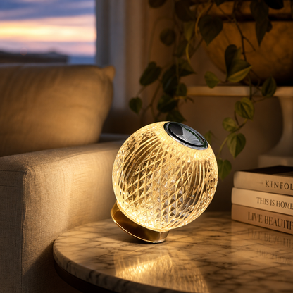 Luminária esfera facetada acesa em mesa lateral de mármore na sala de estar