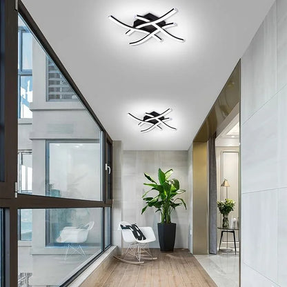 Luminária de Teto LED Curva preta iluminando corredor com poltrona e planta - Vittara Decor
