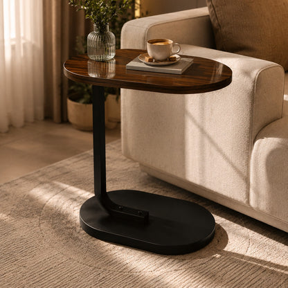 Mesa lateral em C marrom apoiando xícara de café e livro junto ao sofá - Vittara Decor