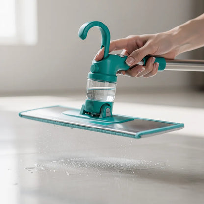 Detalhe do gatilho teal e reservatório transparente do mop spray com jato de água sendo acionado sobre piso - Vittara Decor