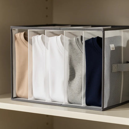 Detalhe da malha transparente e divisórias verticais do organizador de roupas mostrando camisetas dobradas em bege branco cinza e azul marinho - Vittara Decor