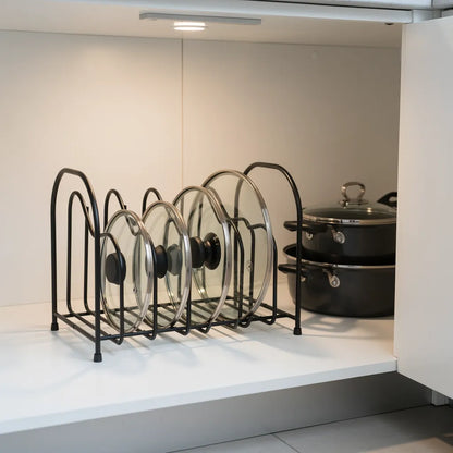 Organizador porta tampas preto dentro de gabinete branco aberto com tampas organizadas e panelas ao lado - Vittara Decor
