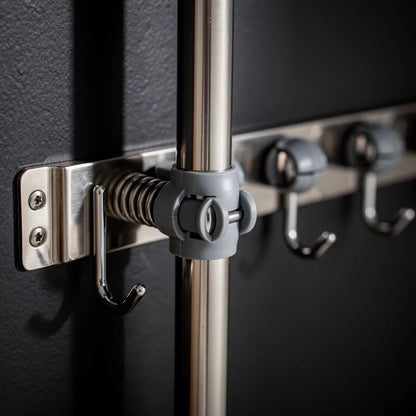 Detalhe do clamp de plástico cinza com mola do suporte para vassouras inox segurando cabo de vassoura firmemente - Vittara Decor