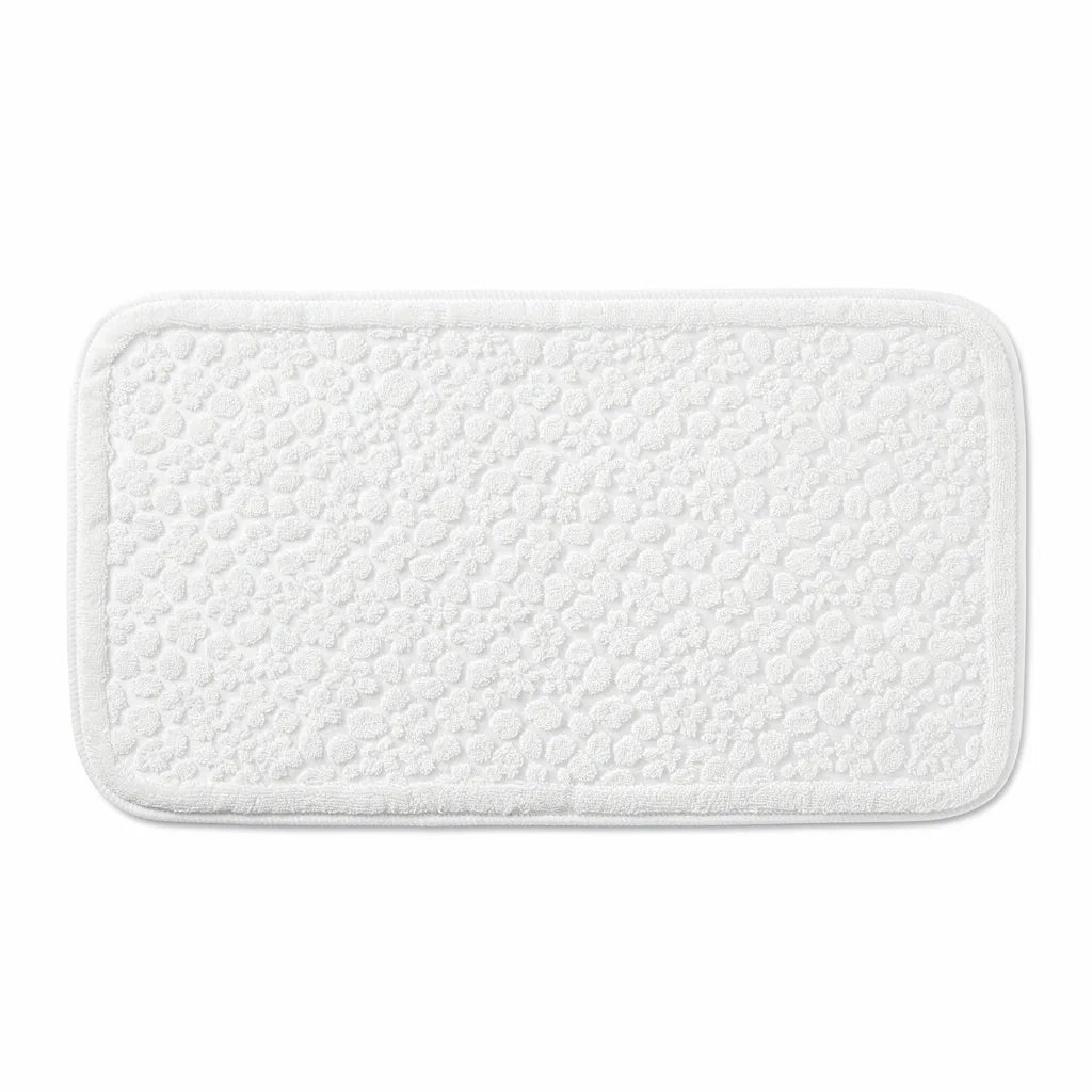 Base PVC antiderrapante do tapete de algodão virada para cima mostrando o padrão de furos que garante aderência ao piso - Vittara Decor