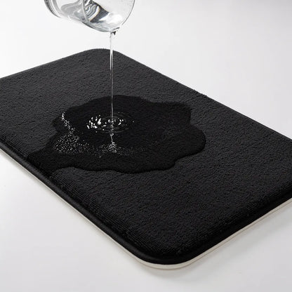 Água sendo derramada sobre o tapete veludo preto mostrando absorção instantânea na superfície de microfibra sem deixar poça - Vittara Decor