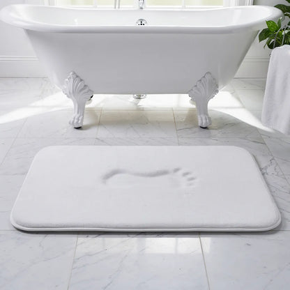 Tapete antiderrapante veludo branco posicionado em frente à banheira freestanding em banheiro claro com luz natural - Vittara Decor