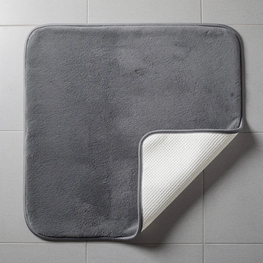 Tapete veludo cinza parcialmente levantado mostrando a base antiderrapante off-white que evita deslizamento no piso - Vittara Decor